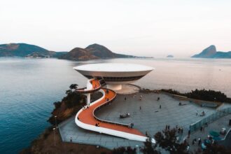 A breathtaking aerial view of the Niterói Contemporary Art Museum in Brazil, surrounded by sea and mountains.