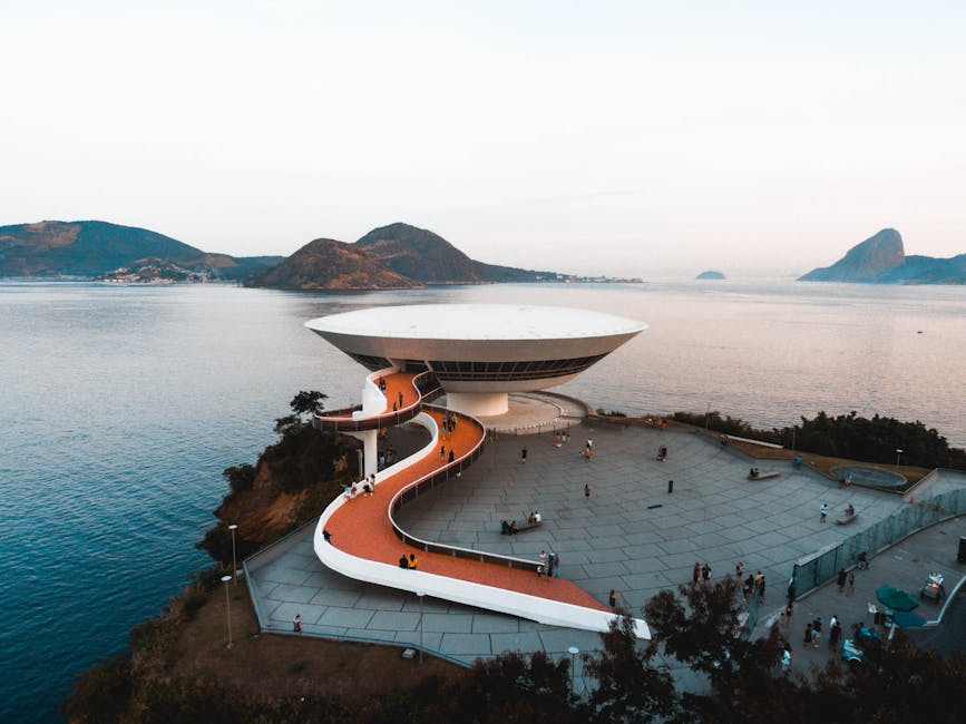 A breathtaking aerial view of the Niterói Contemporary Art Museum in Brazil, surrounded by sea and mountains.